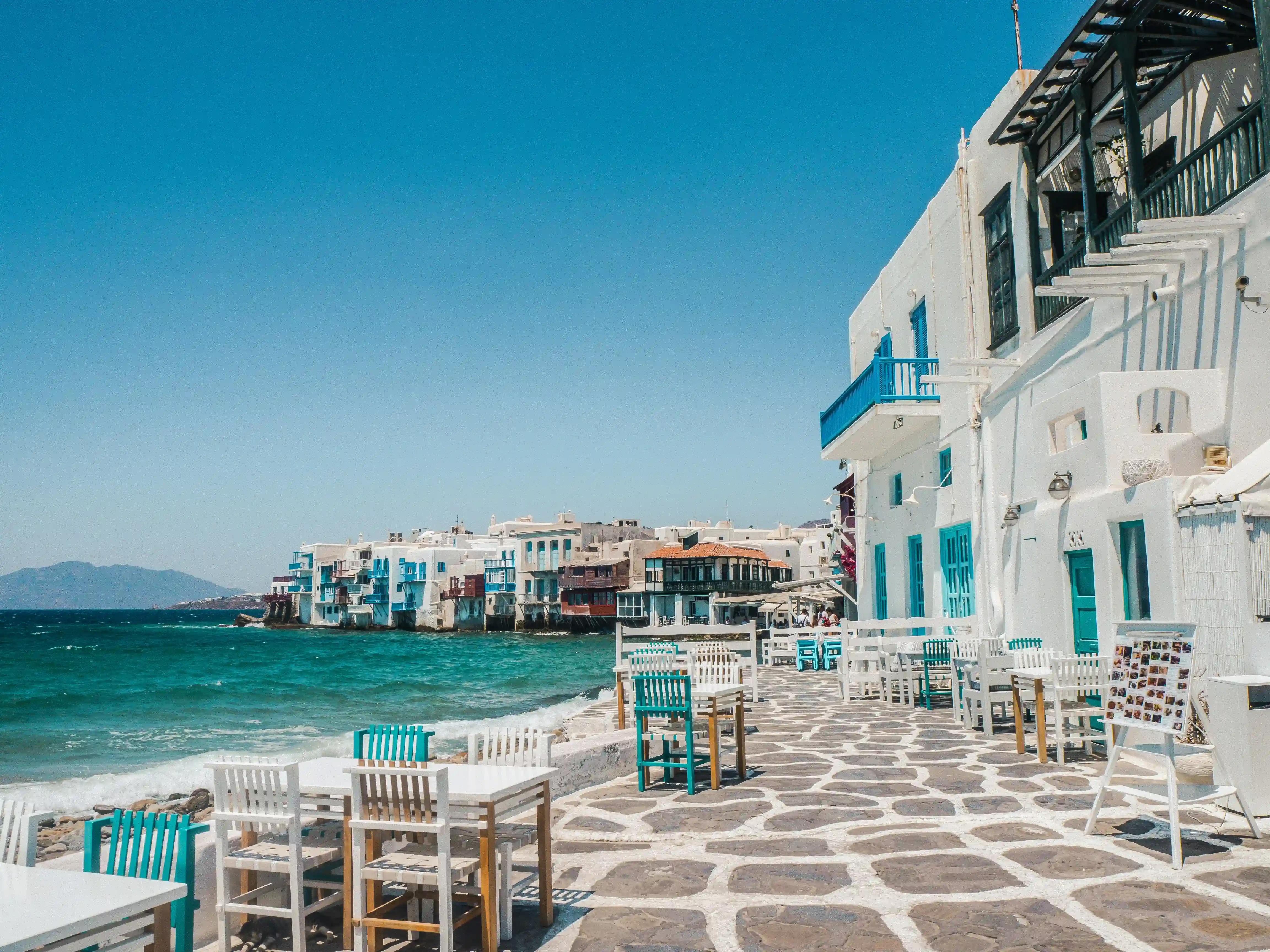 White stone village on the cliffs of a Greek island overlooking the deep blue Aegean Sea